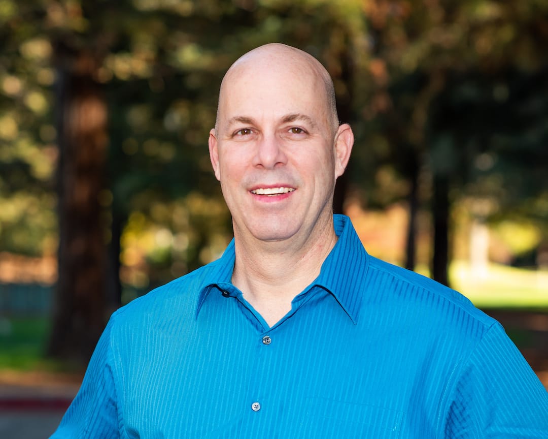 Doug Olive, SF Bay Area Notary, stands for a headshot in a park.